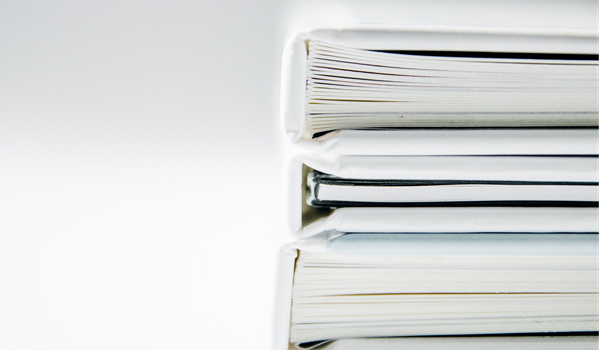 a close up stack of white folders filled with paper